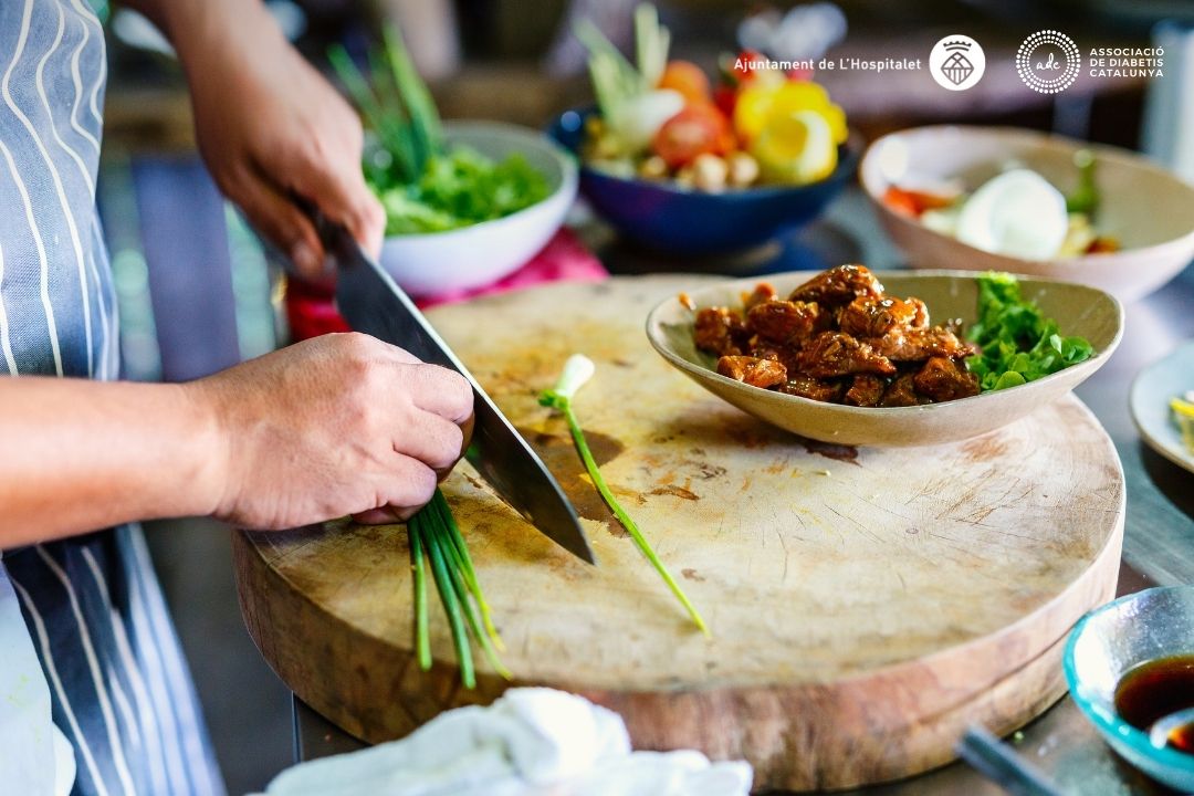 persona tallant vegetals. Logo ADC i Ajuntament de l'Hospitalet